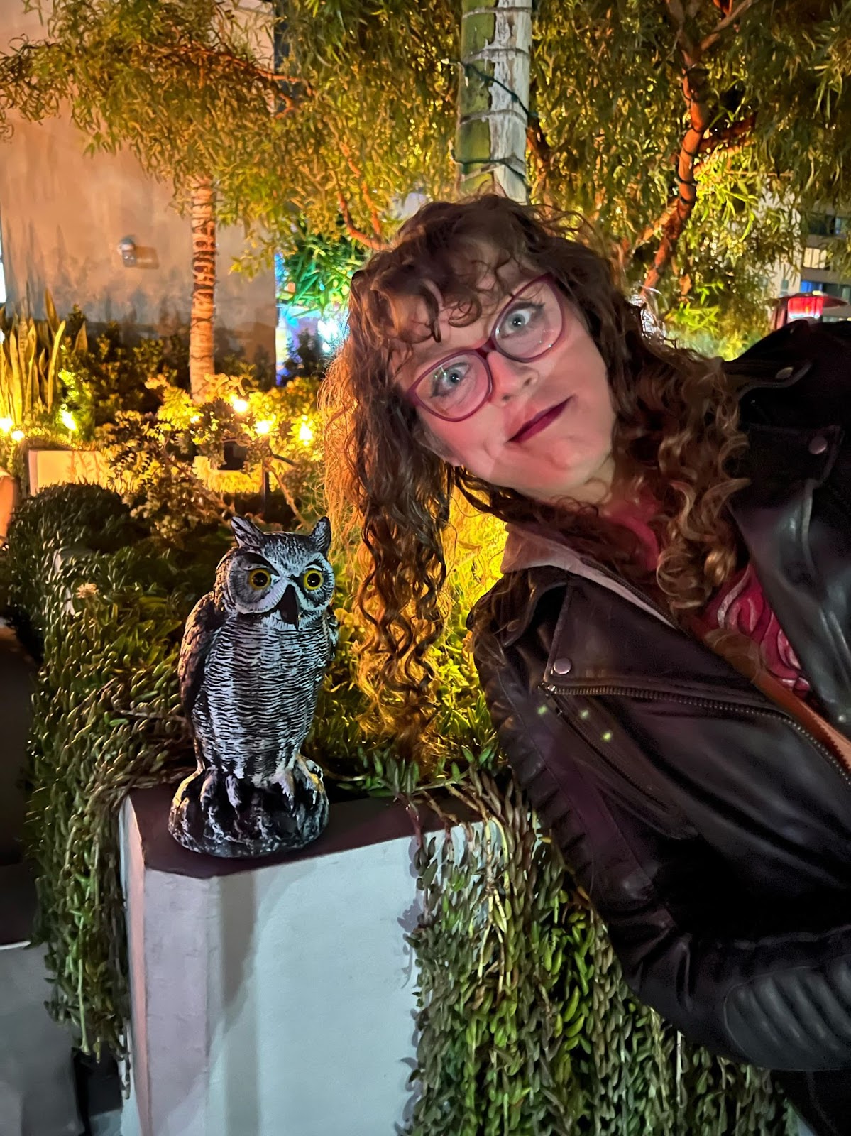 Me leaning over and making a goofy face in front of a small owl statue