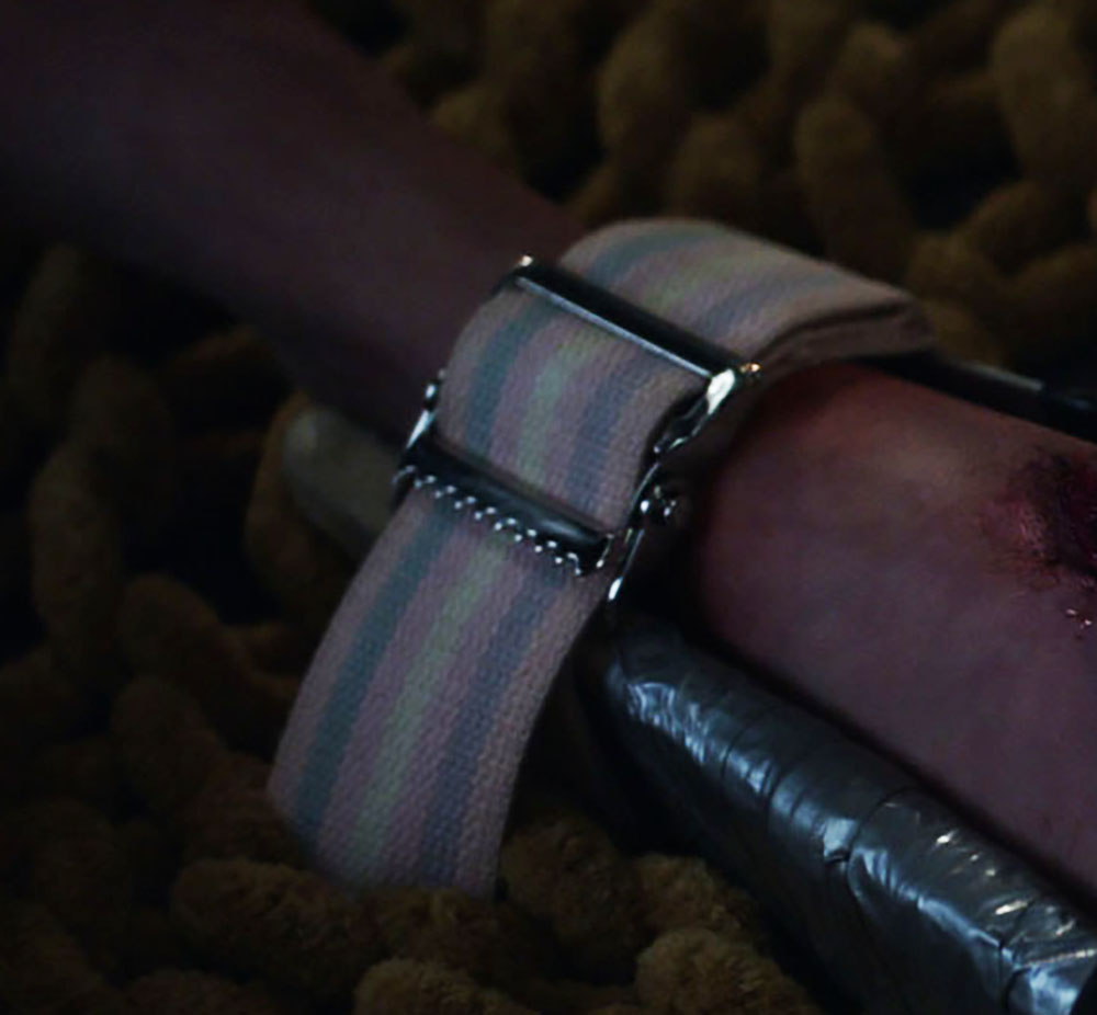 Closeup on the pink/blue/pink/white/pink/blue/pink strap buckled around the brace.