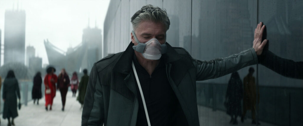 captain pike in a breathing mask, with one hand on a building for support