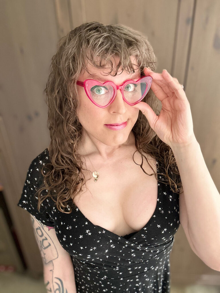 Me in a low cut black dress covered in white stars, and lo and behold: cleavage! aww yeah. and i am adjusting my pink heart shaped glasses just to be sure I’m seeing things correctly. ha.