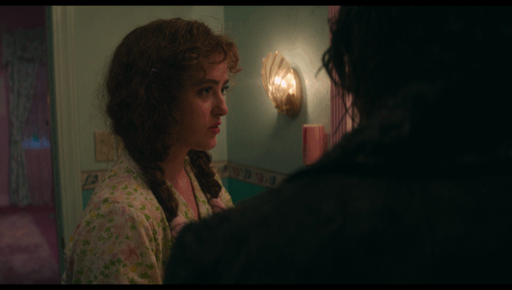 Lisa looks at the mirror on an angle, so she can see Frank’s reflection. In the shot, Frank himself blocks that reflection so we can’t see it.