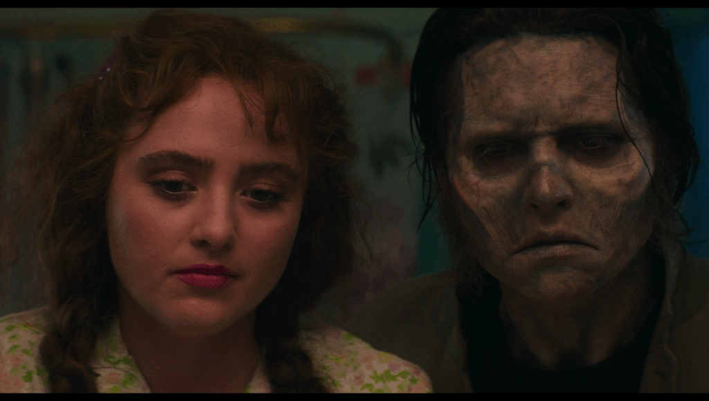 Lisa and Frank as seen in a mirror reflection, looking sad