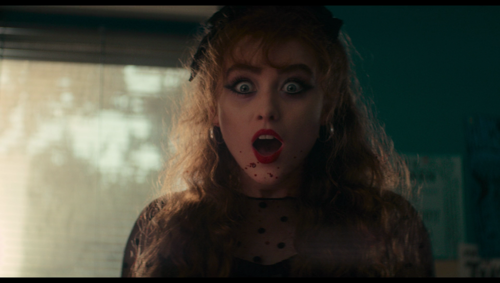 Lisa looking surprised and excited as blood splatters on her face