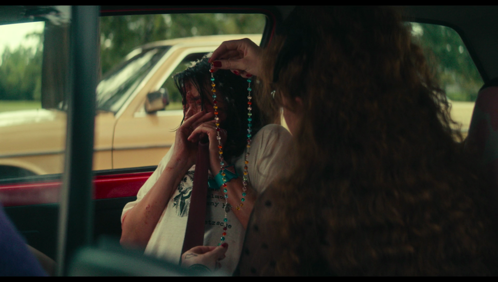 In Taffy’s car, Lisa hands Taffy her mom’s rosary.