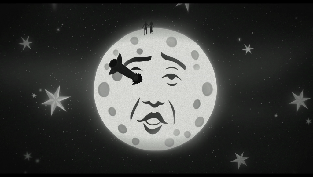 Black and white animated image of a rocket in the man in the moon’s eye, as a man and woman’s silhouettes walk over the top of it.