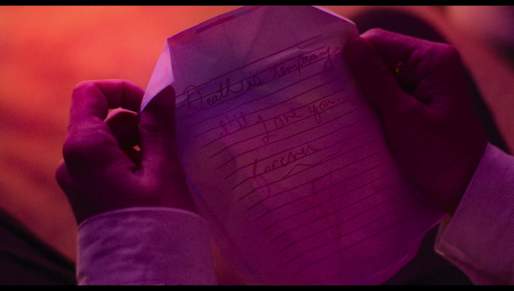 Frank holds Lisa’s handwritten note, which reads “Death is temporary. I’ll love you forever.” And is signed with a lightning bolt.