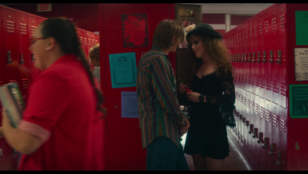 A girl in red walks by in the foreground.