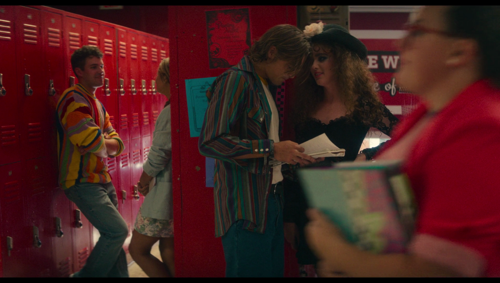 The same girl in red walks by in the foreground. Again.