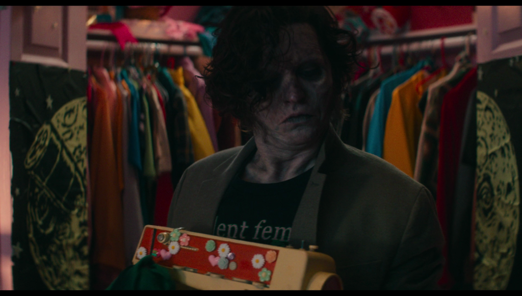 Frank steps out of the closet, holding a sewing machine.