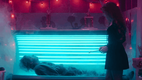 animated gif from Lisa Frankenstein of the creature rising from the tanning bed like a corpse rising from a grave, as Lisa stands nearby in a tiara and holding a magic wand