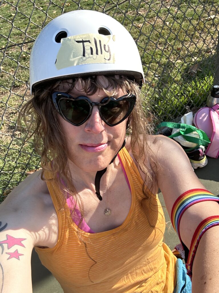 Me in workout clothes and loaner derby gear, with pink lipstick on