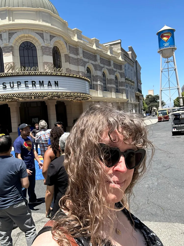 Me on the Warner Bros lot in front of their theater, showing Superman, with the Superman-shield wrapped WB water tower in the background